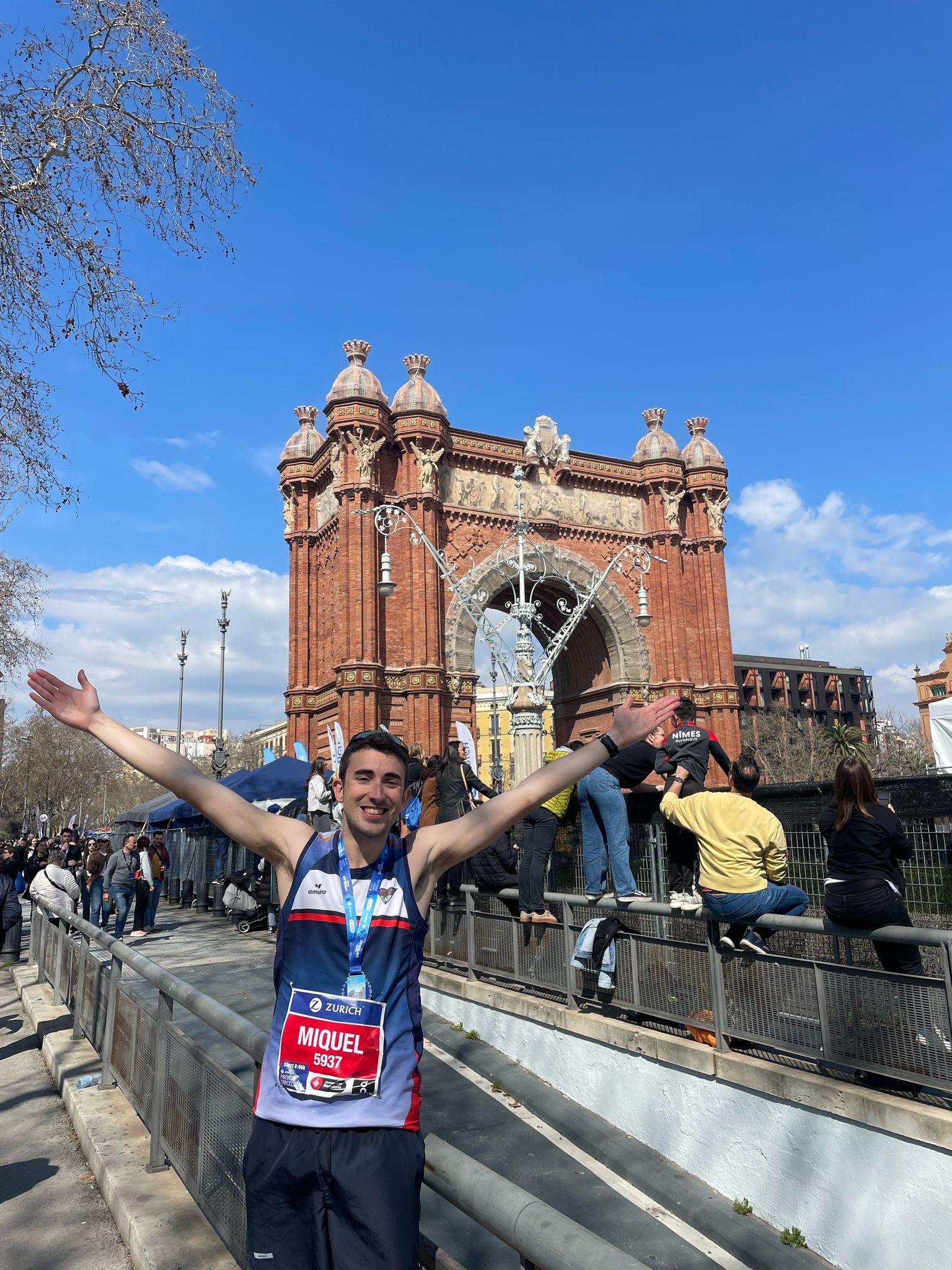 Miquel Batlle con dorsal Zurich Maratón de Barcelona número 5937 frente al Arco de Triunfo celebrando